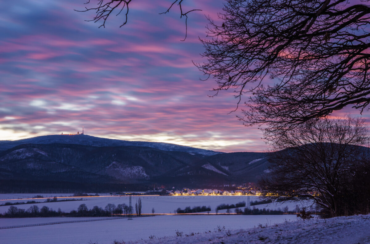 Abendhimmel über verschneiter Landschaft. Blick auf Brocken und Darlingerode.